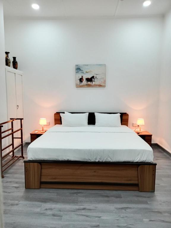 a bedroom with a bed with two tables and two lamps at White Room in Colombo Seven in Colombo