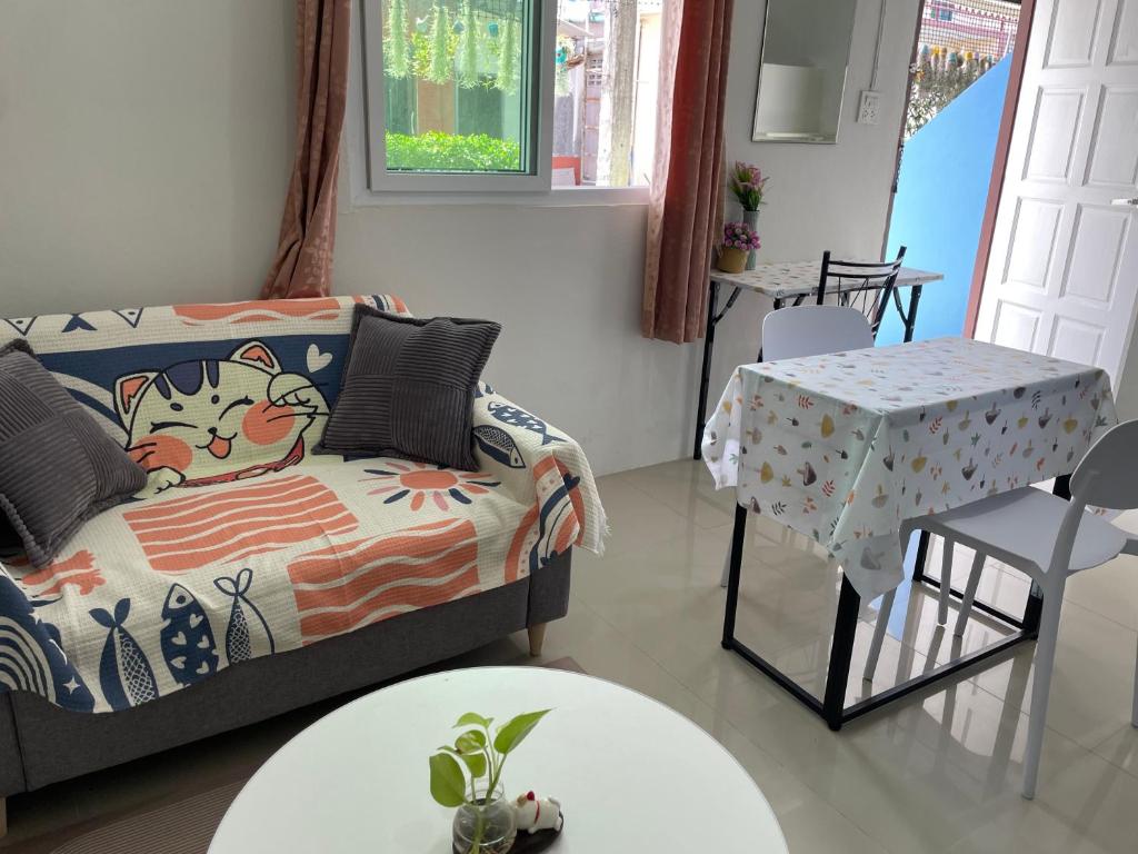 een woonkamer met een bank en een tafel bij Yada House twin bed in Nai Yang Beach