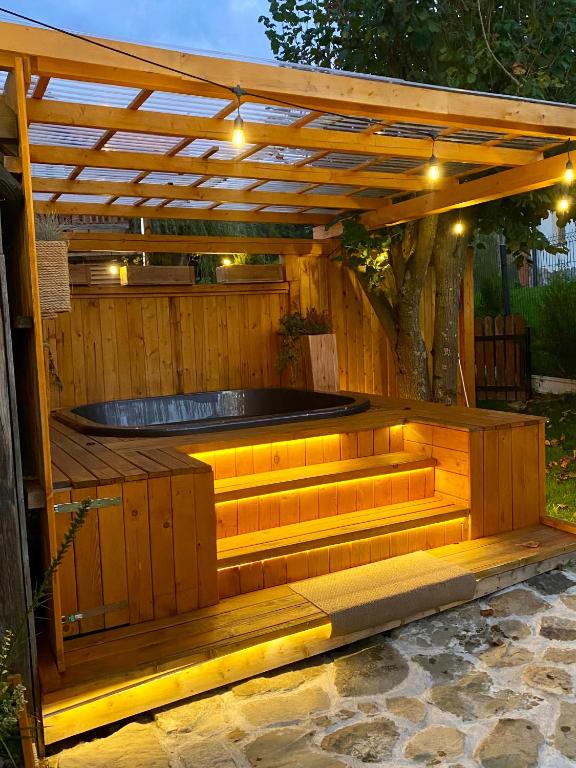 a hot tub in a wooden deck with a wooden pergola at Babie Domki z sauną i jacuzzi in Zawoja