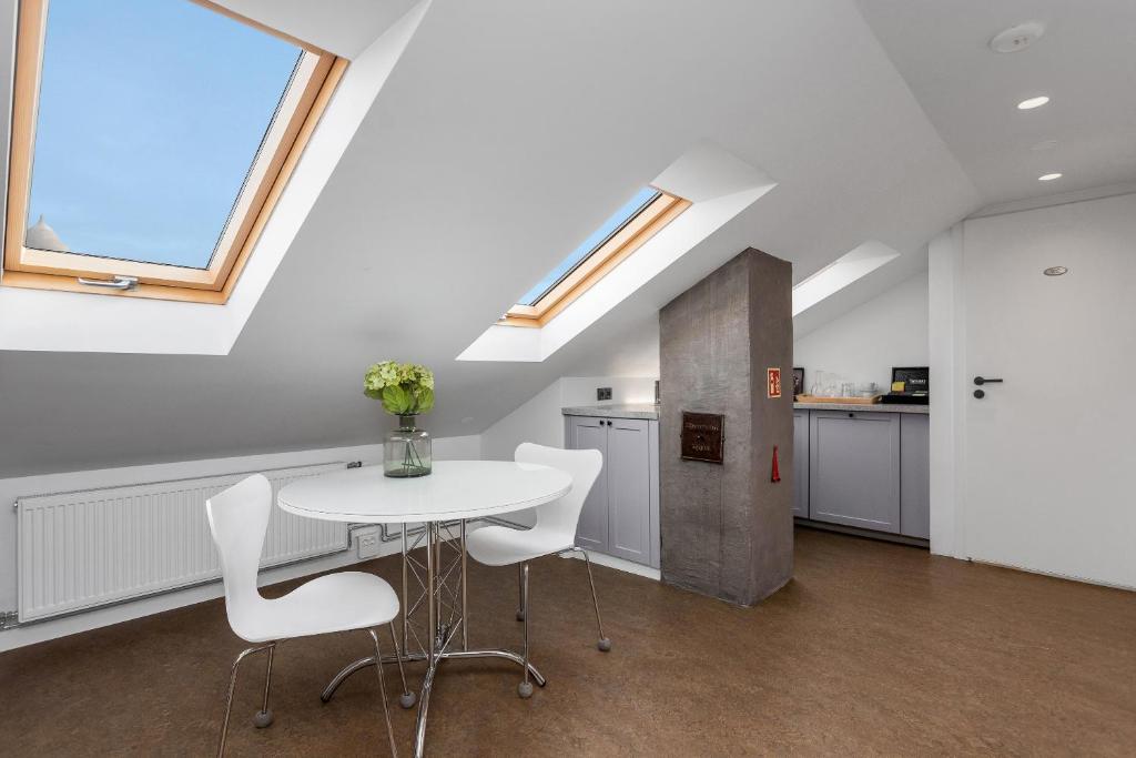 a kitchen with a white table and white chairs at Freyja Guesthouse & Suites in Reykjavík