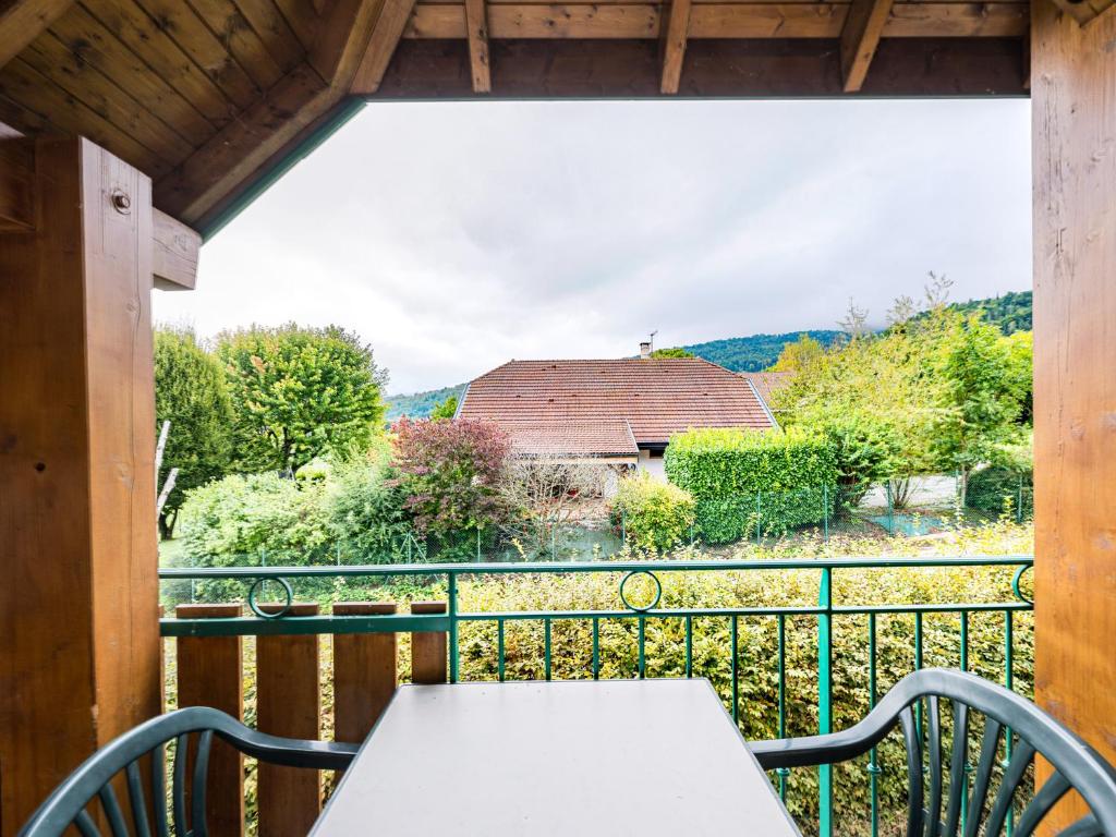 a balcony with a table and a view of a barn at Birdie E N23 - ST4 in Giez