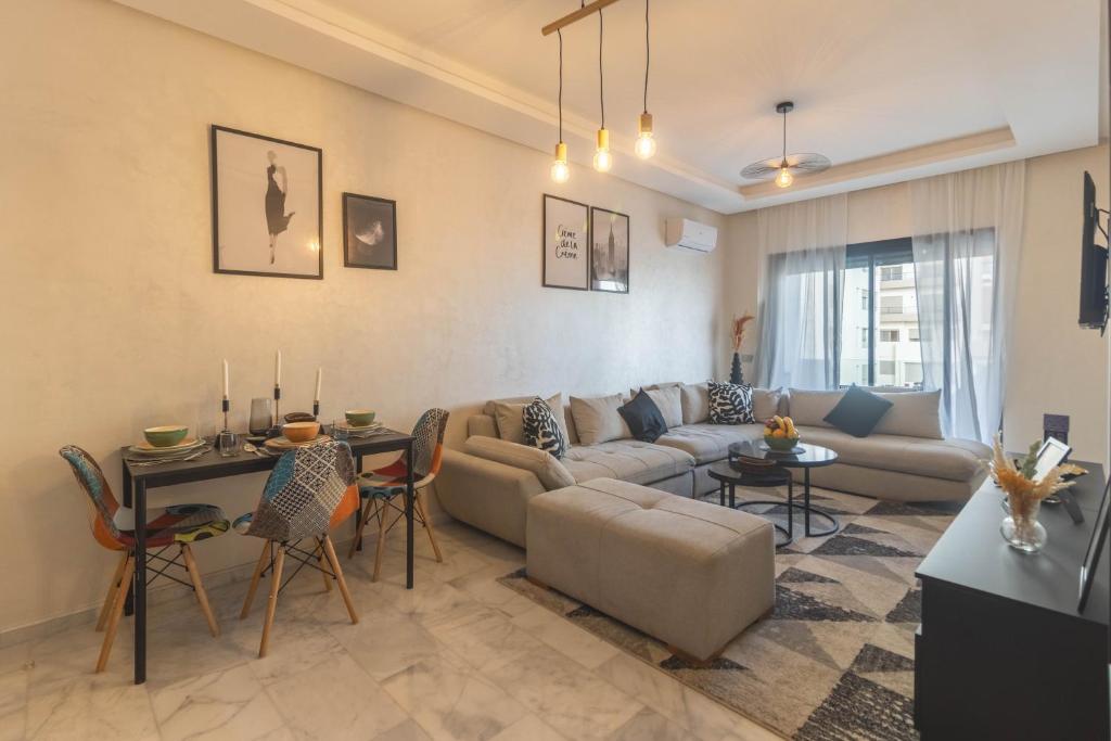 a living room with a couch and a table at Studio chic et paisible avec piscine parc et plage in Aïn Harrouda