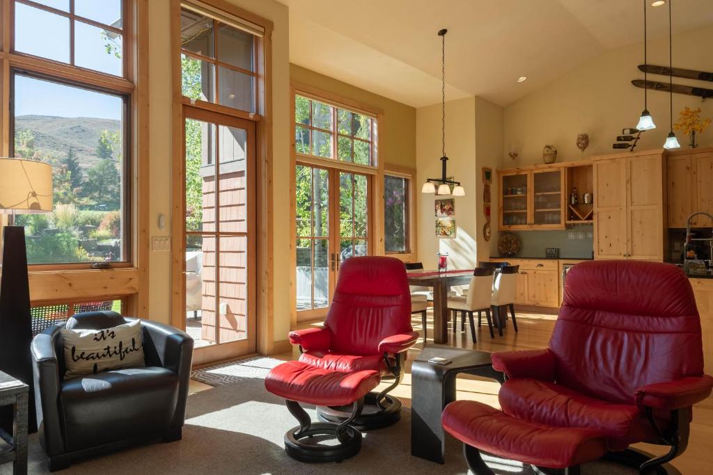 een woonkamer met rode stoelen en een keuken bij Angani Way Townhome 104 in Elkhorn Village