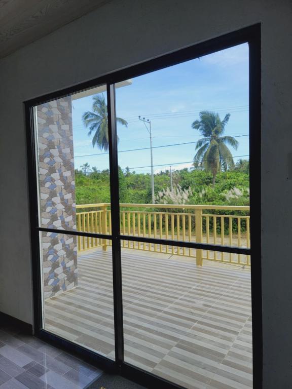 a sliding glass door with a view of a deck at Siargao Villaflor Residence in Dapa