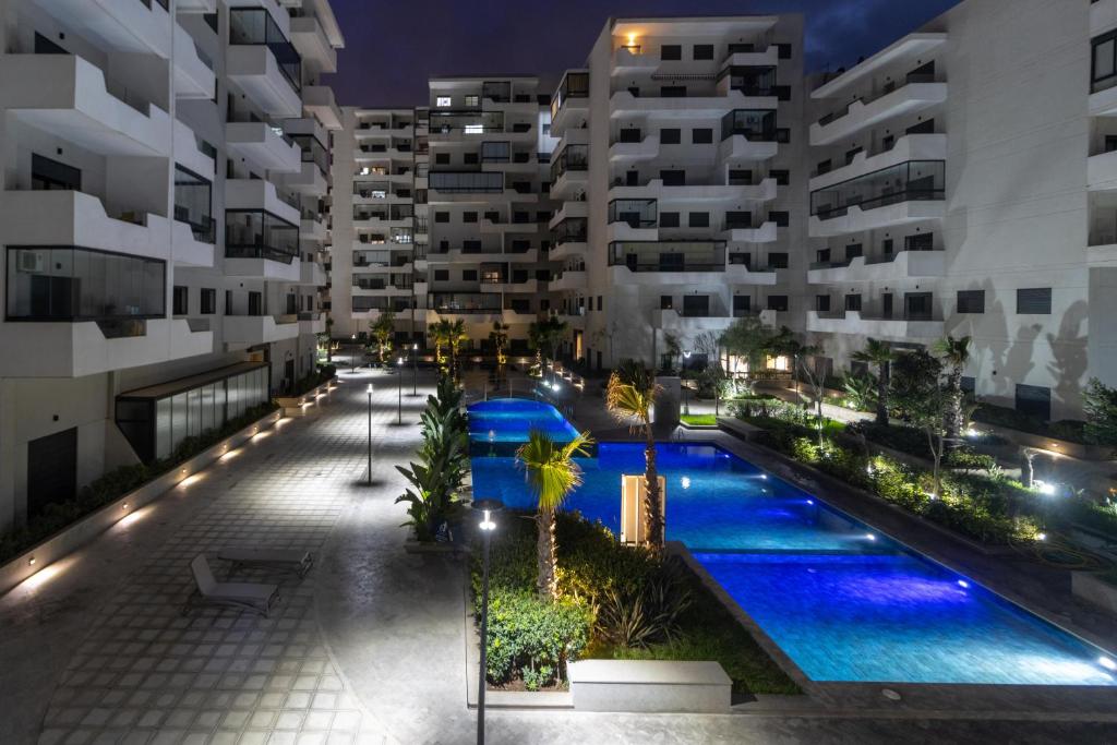 eine Luftansicht eines Apartmentkomplexes in der Nacht in der Unterkunft Studio chic et paisible avec piscine parc et plage in Aïn Harrouda