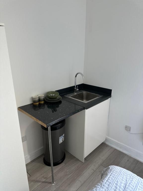 a kitchen with a sink and a counter at Comfort Rooms - East Croydon in South Norwood