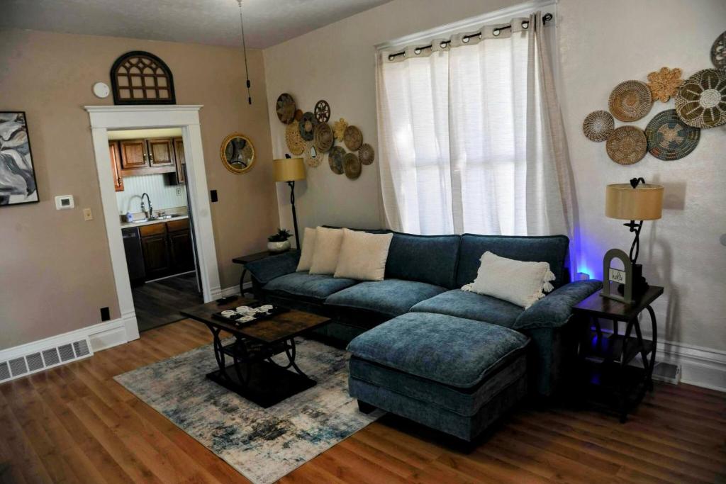 Una sala de estar con un sofá azul y una mesa. en 3 Bed Bath with yard and Fire Pit- Charming Small Town Exploring, en Bremen