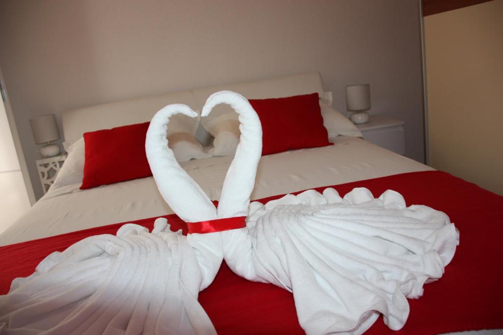 two white swans are forming a heart on a bed at Apartment Nina in Split