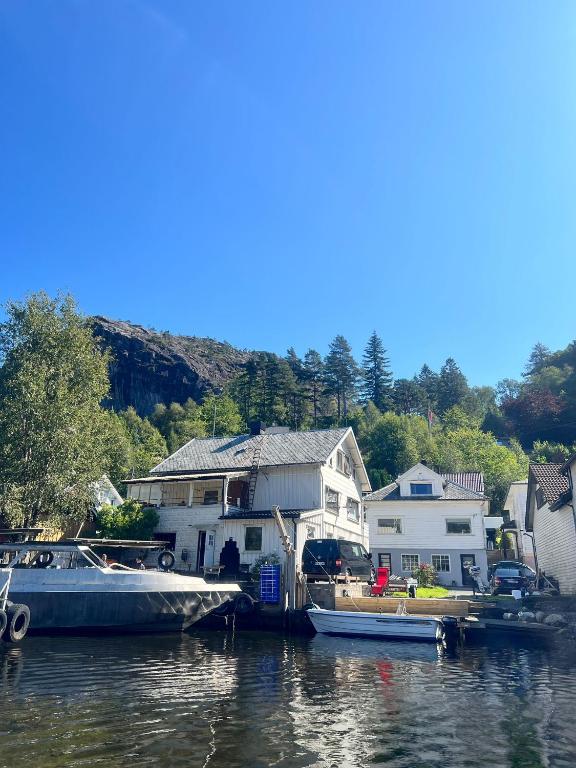 a couple of boats are docked next to some houses at ASFeriehus in Flekkefjord