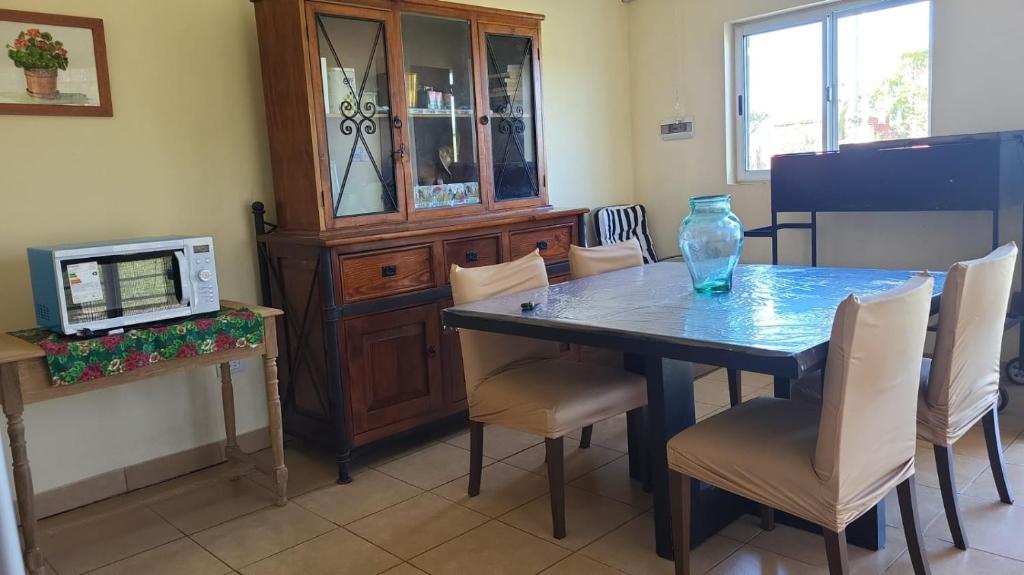 a dining room table with chairs and a glass vase on it at Chacra MARIANA in Gualeguay