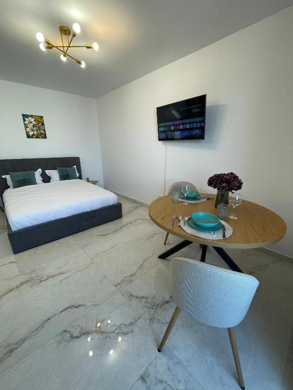 a bedroom with a bed and a table with a chair at Urban Sud Residence in Giroc