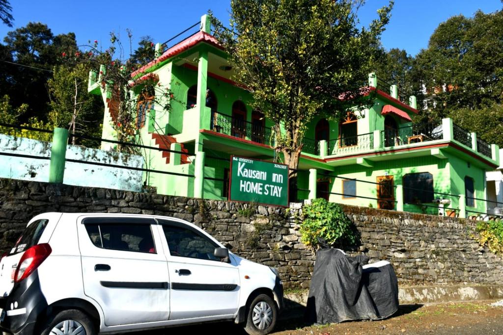 考萨尼Kausani Inn homestary的绿色房子前面的白色汽车