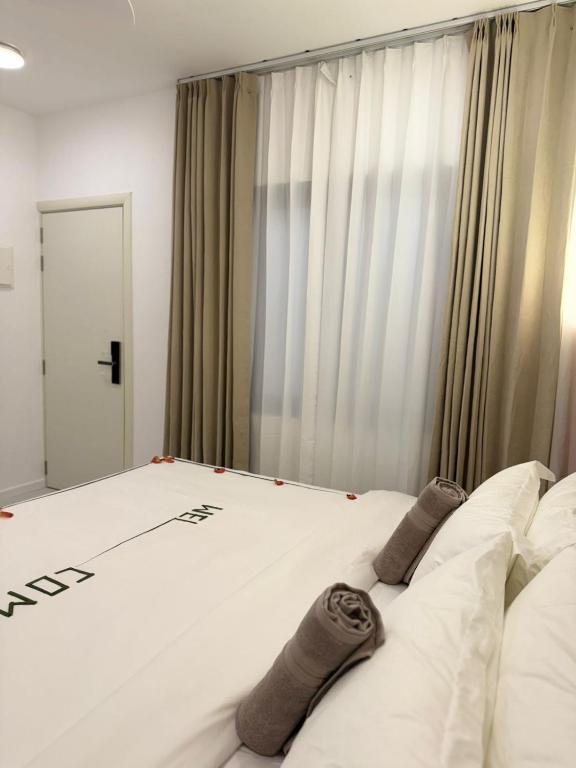 a bedroom with a large white bed with socks on it at Ranveli Dhigurah in Dhigurah