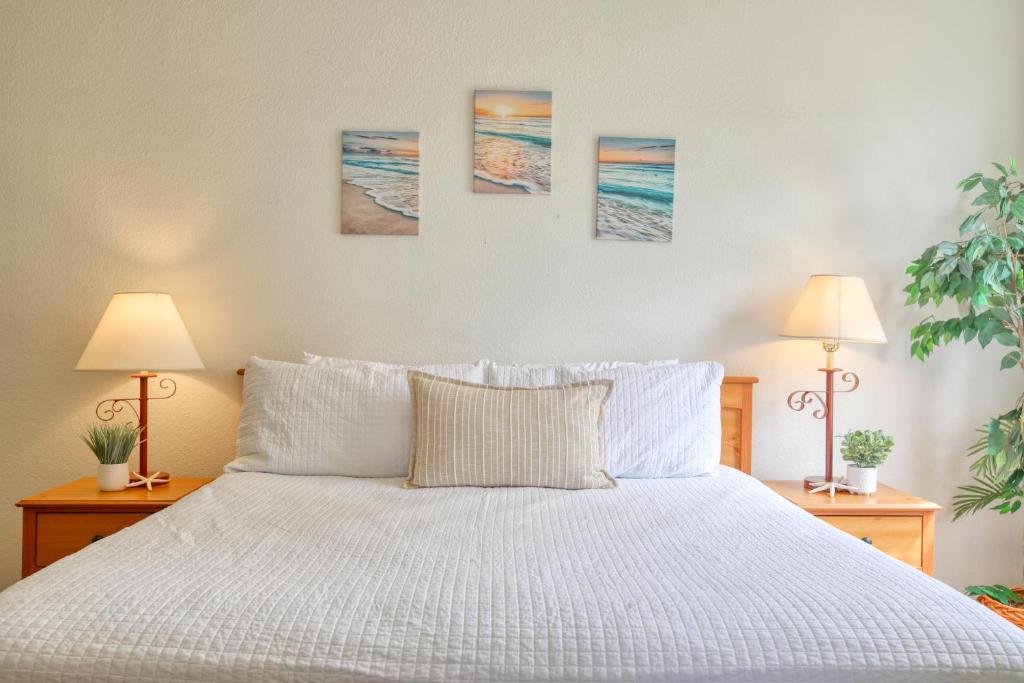 a bedroom with a white bed with three paintings on the wall at Pacific Plaza #504 - Heart of Oceano - 1BdrmD-King in Oceano