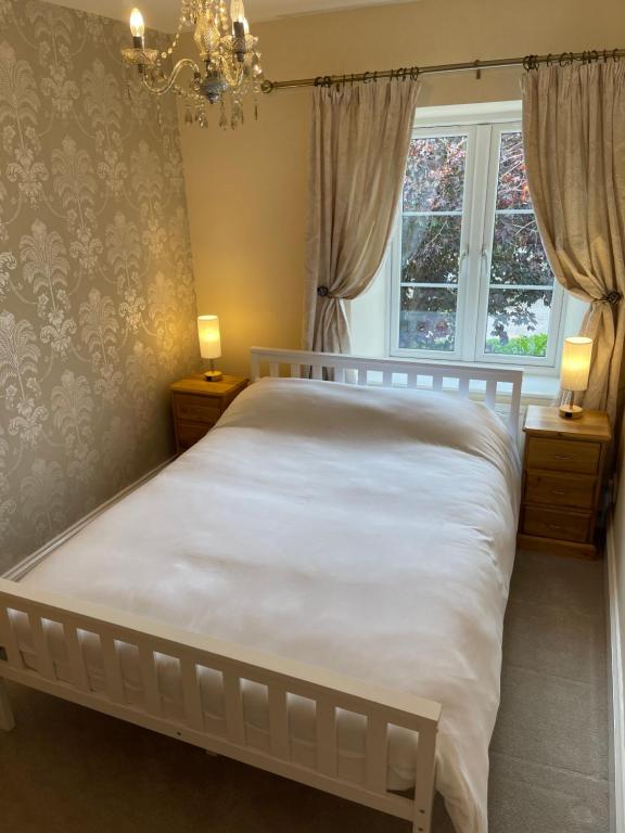 a bedroom with a white bed and a window at Chew Valley Retreat Suite in Bishop Sutton