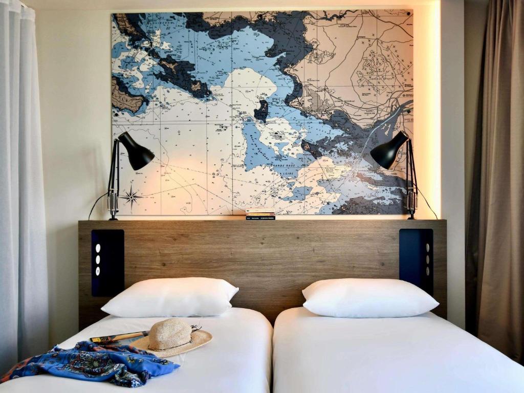 サン・ナゼールにあるibis Styles Saint Nazaire Centre Gareのベッド2台(壁に地図付)