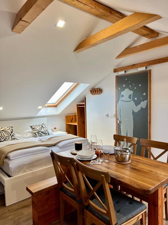 a bedroom with a bed and a table and chairs at BeeWood apartment in Križe