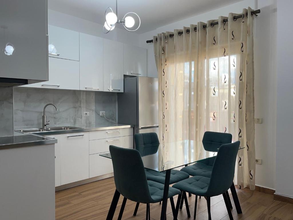 eine Küche mit Tisch und Stühlen und einer Spüle in der Unterkunft Elena residence in Tirana