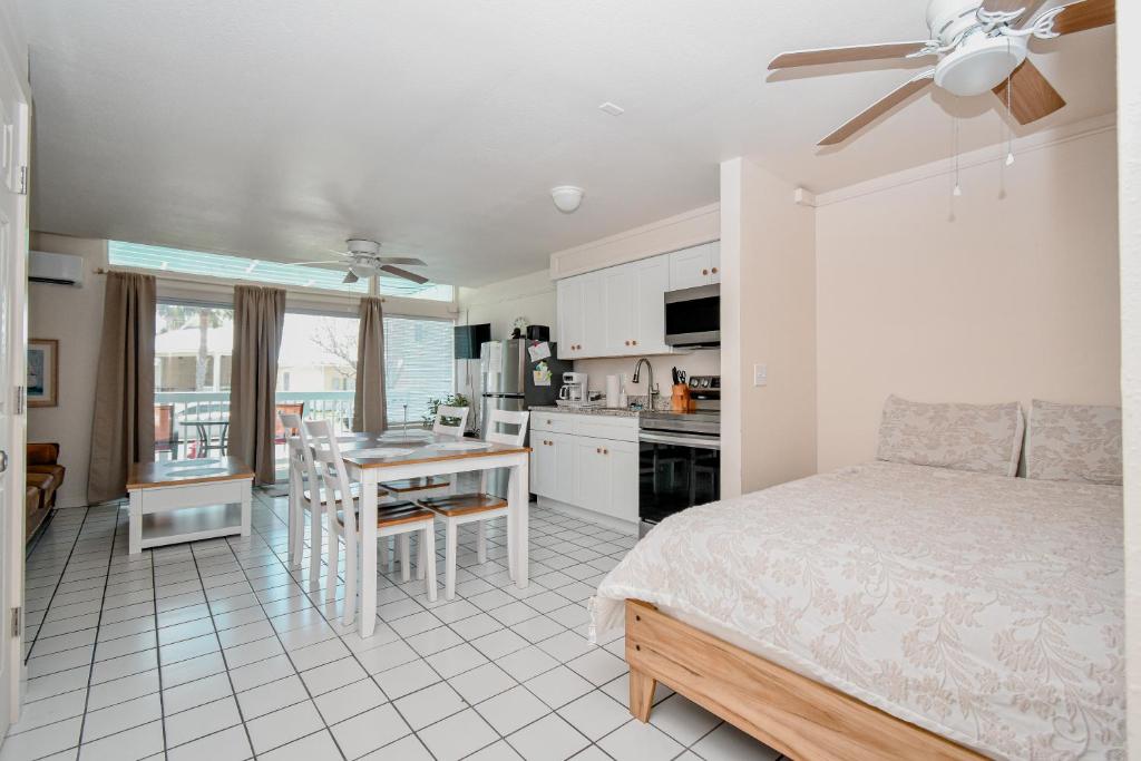 a bedroom with a bed and a kitchen with a table at Park Place Unit 122 in Cedar Key