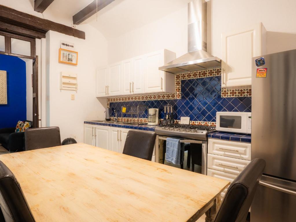 a kitchen with a wooden table and a refrigerator at Casa colonial en el corazón del Centro Histórico in Mexico City