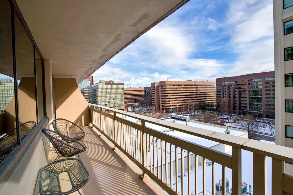 a balcony with two chairs and a view of a city at A Few Steps From Airport - Stylish Apt in Addison Heights