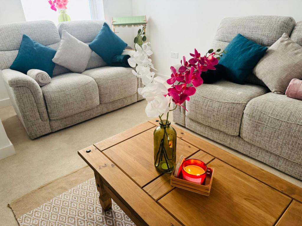 a living room with a vase with flowers on a coffee table at Cosy Home Stay in Nottinghamshire in Retford