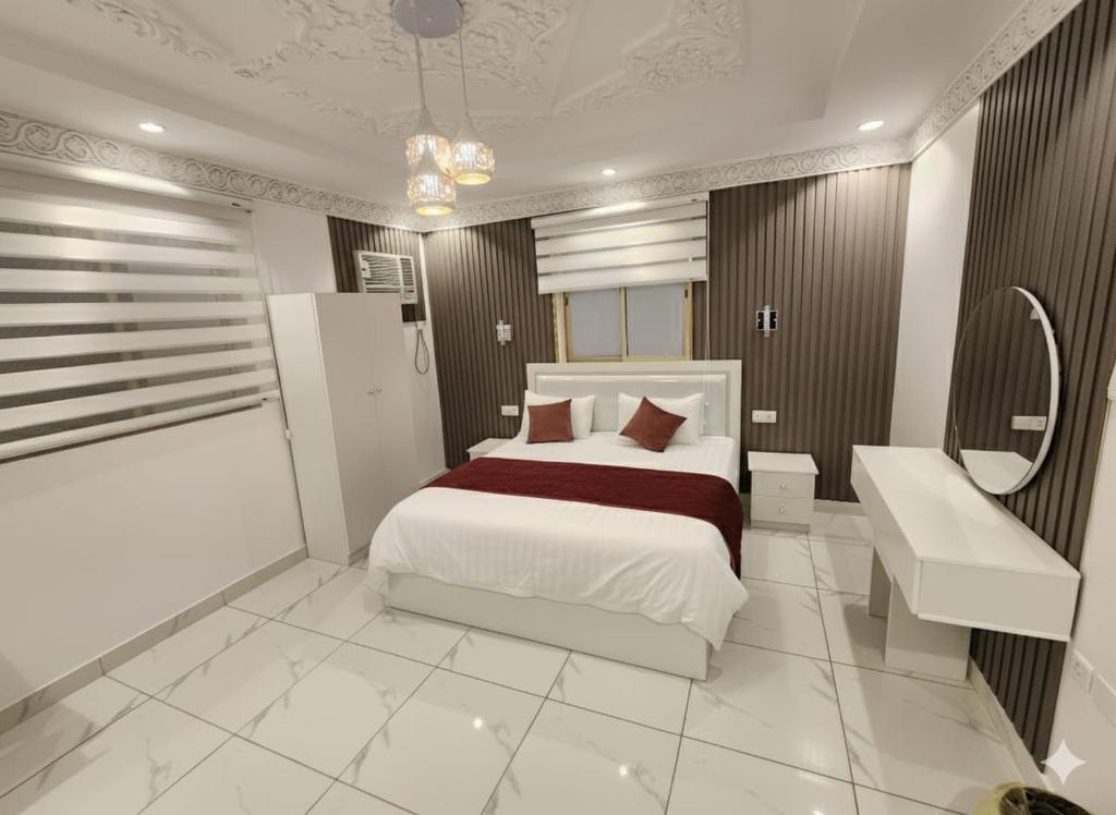 a bedroom with a white bed and a sink and a bed petertodd at إيوان الفخامة in Al Madinah