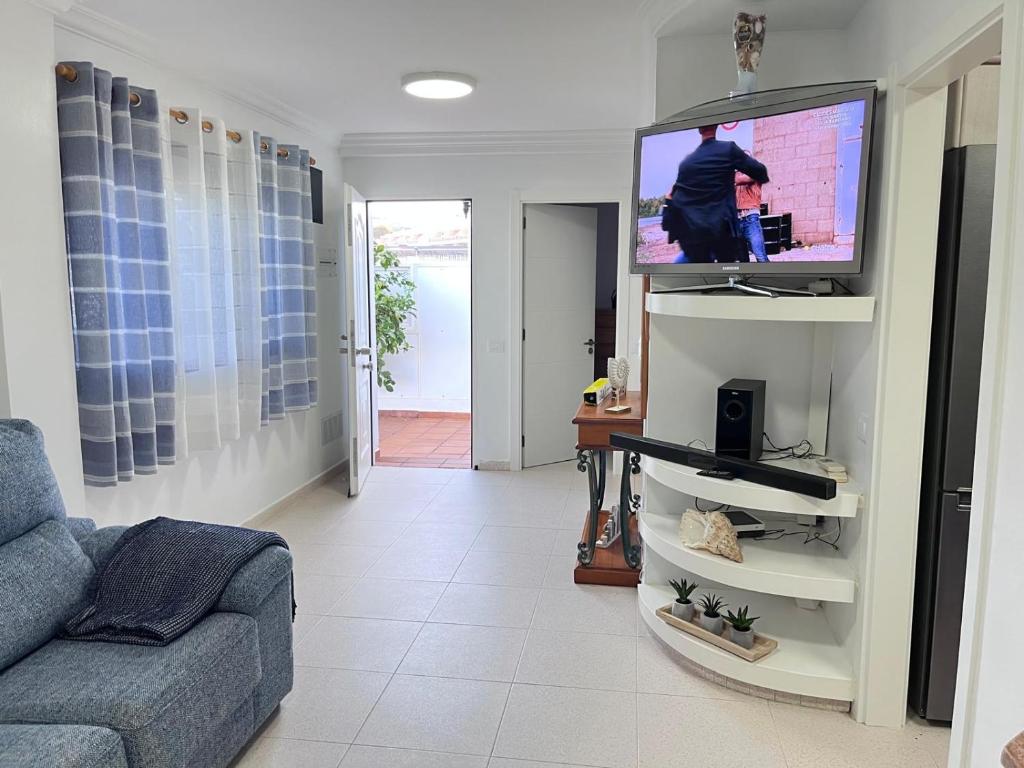 a living room with a couch and a flat screen tv at Malihana- Duplex con vistas y BBQ en Puerto Rico in Mogán