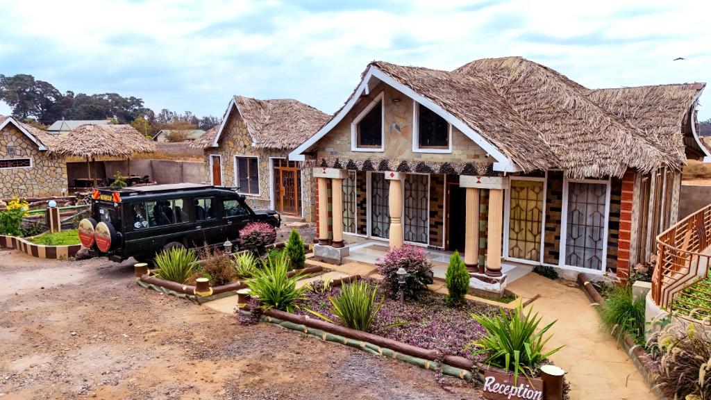 a house with a truck parked in front of it at Amboseli Likizo Lodge in Kimana