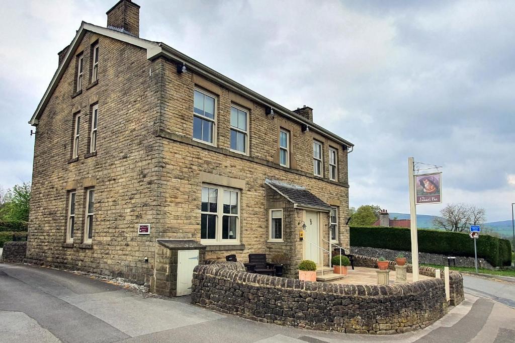 a large brick building with a stone wall at Samuel Fox, Bradwell Hope Valley in Bradwell