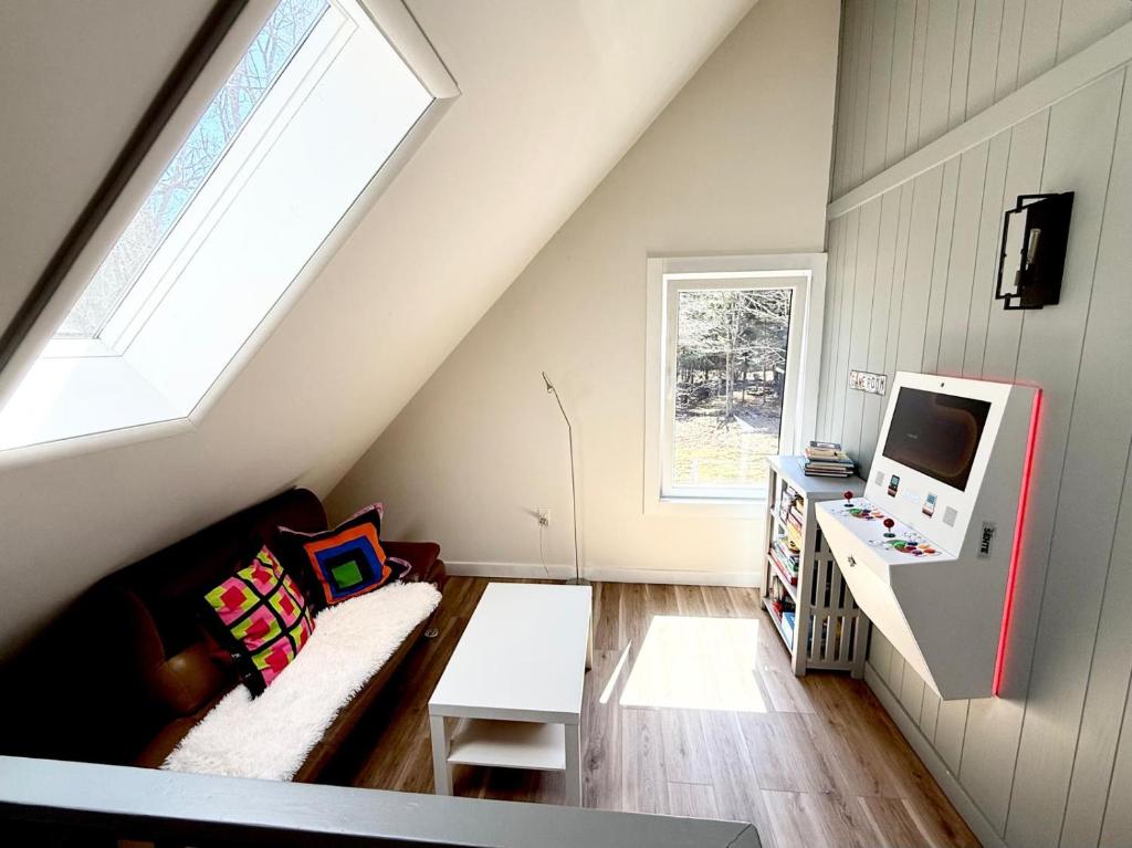 a attic living room with a couch and a tv at Pocono Chalet,Hot Tub,Arcade,Fireplace, Lake,Pool, Pet friendly, near Jim Thorpe No extra fees to use amenities in Towamensing Trails