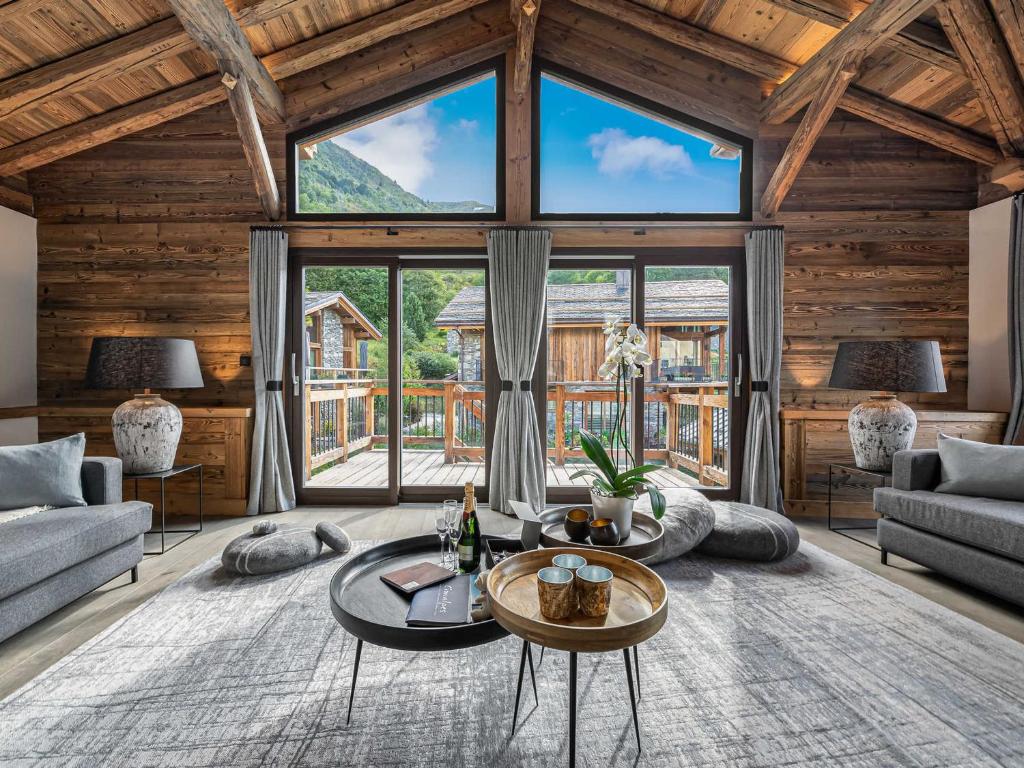 a living room with a table and a large window at Chalet savoyard 5 chambres avec sauna, navette gratuite et prestations haut de gamme, proche pistes - FR-1-570-8 in Saint-Martin-de-Belleville