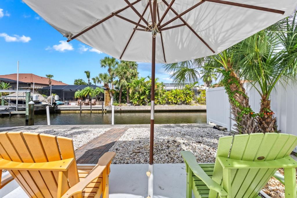 a patio with two chairs and an umbrella at Siesta Key Waterfront Oasis - Heated Pool, Dock, Walk to Village & Beach in Bailey Hall