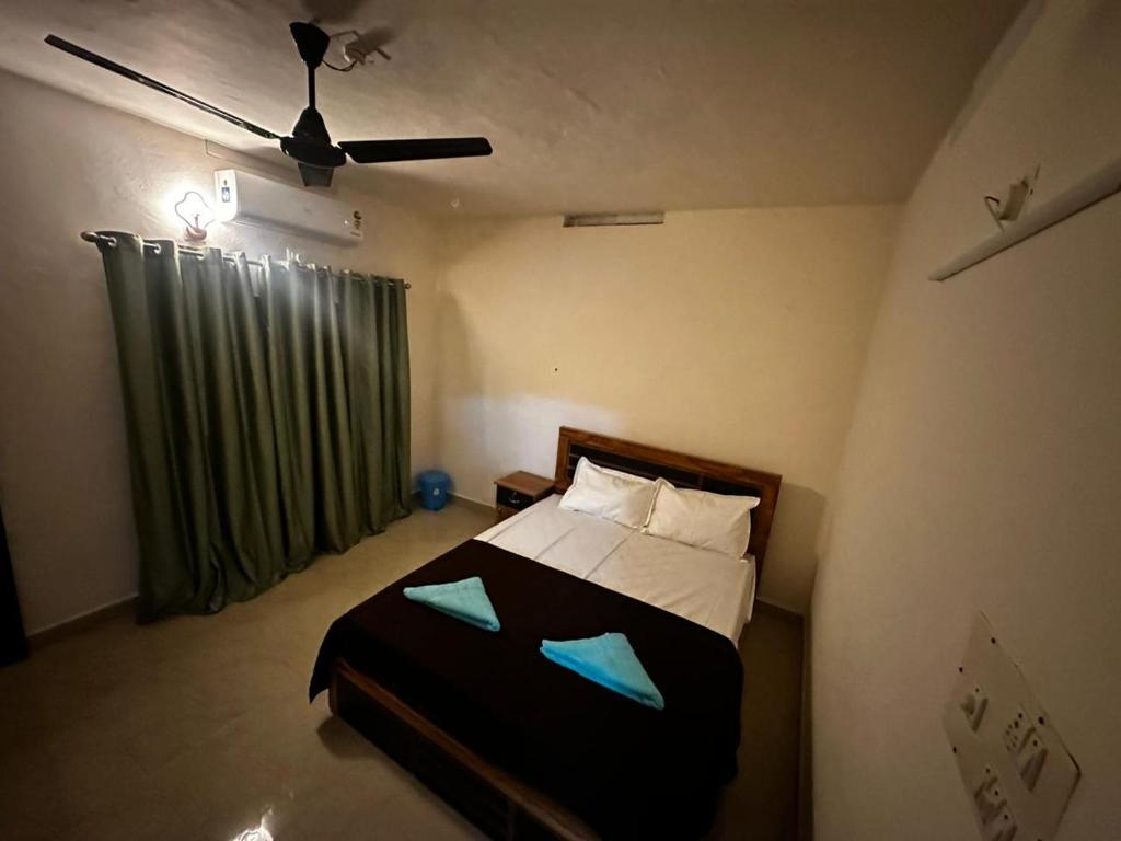 a bedroom with a bed with a ceiling fan at Fleur Haus in Kappil