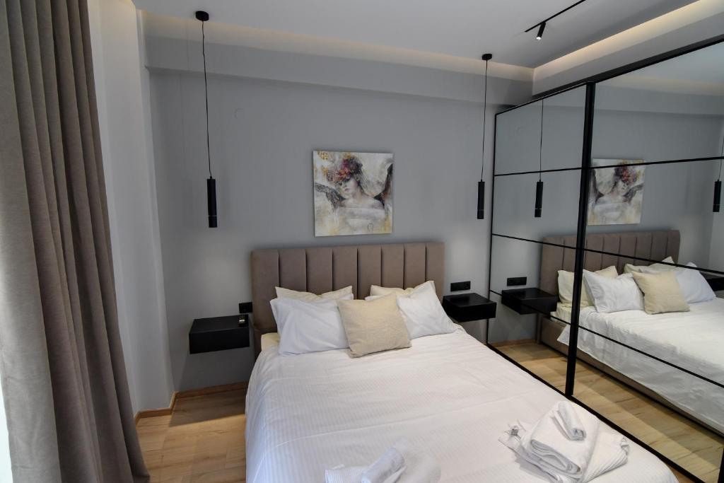 a bedroom with two beds and a mirror at twins luxury studios in Kastoria