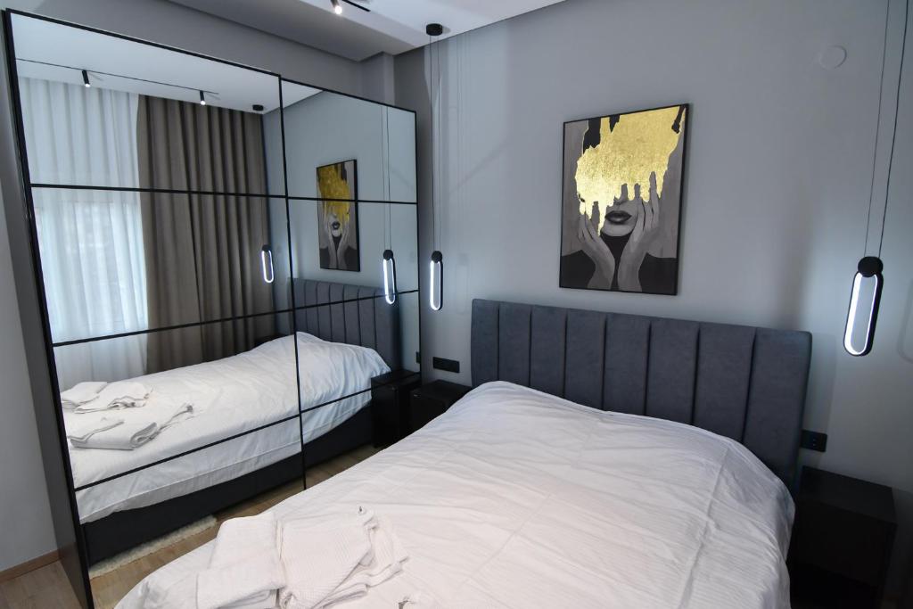 a bedroom with two beds and a mirror at twins luxury studios in Kastoria