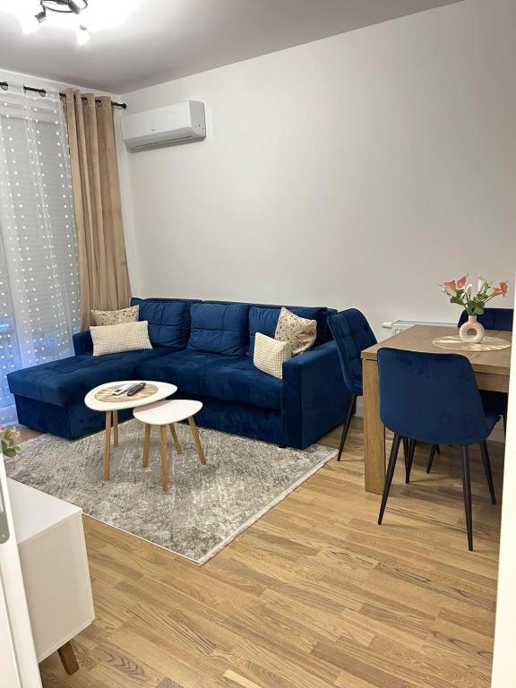 a living room with a blue couch and a table at Apartman Maja in Budžak