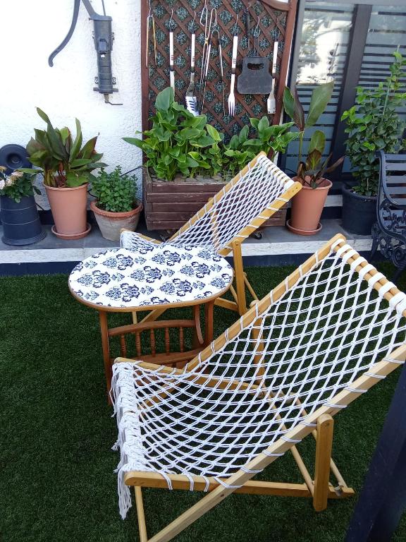 two chairs and a table on a porch with plants at STUDIO Perpignan in Perpignan