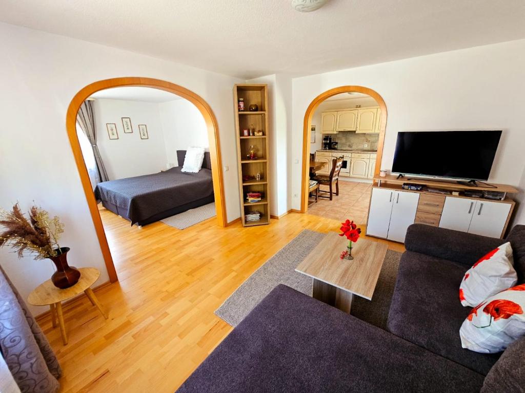 a living room with a couch and a television at Ferienhaus-Drachenfels-Busenberg in Busenberg