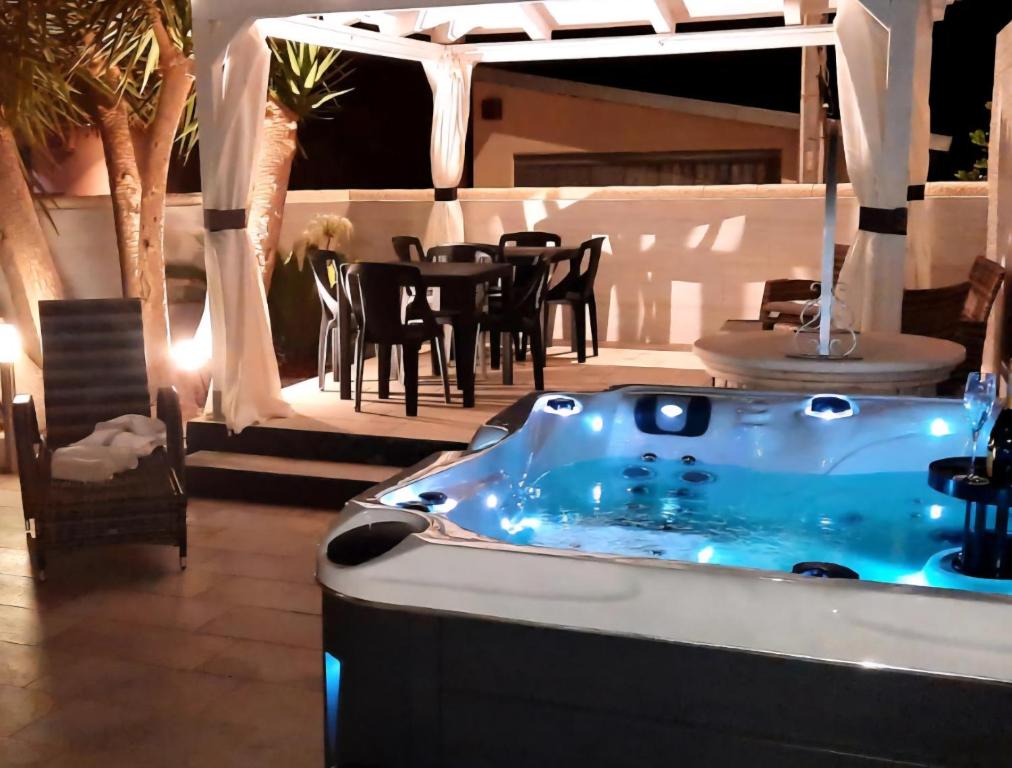 a hot tub in a room with a table and chairs at Villa Anny Fronte Mare in Avola
