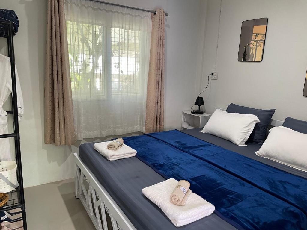 a bedroom with a blue bed with towels on it at Yada House s&h in Nai Yang Beach