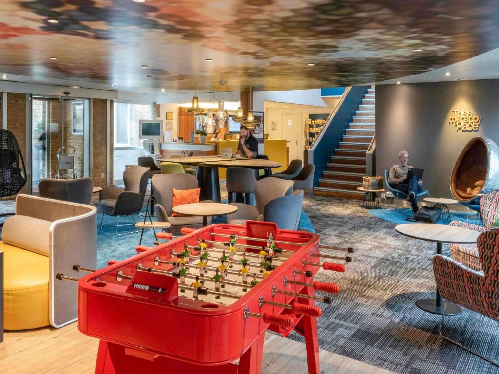 a living room with a chess board on a table at Hôtel Novotel Valenciennes in Valenciennes