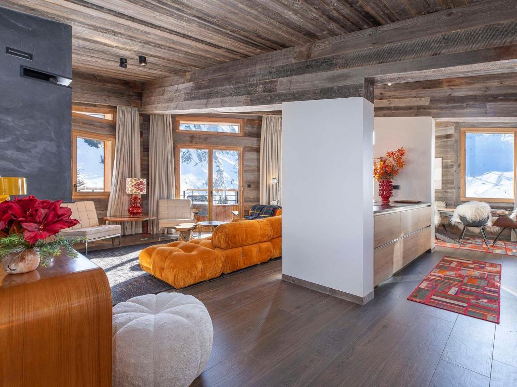 a living room with orange furniture in a room at Chalet Haut de Gamme à Avoriaz - 11 Pers, Ski-in/Ski-out, Sauna, Terrasses Panoramiques, Service Premium - FR-1-314-114 in Morzine