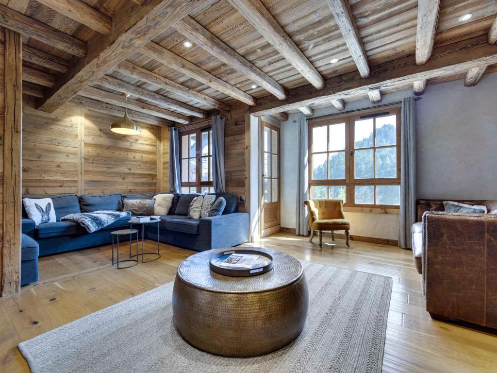 a living room with a blue couch and a wooden ceiling at Arc 1950: Apt 10 pers, 4 ch, ski pieds, wellness, wifi - FR-1-686-44 in Arc 1950