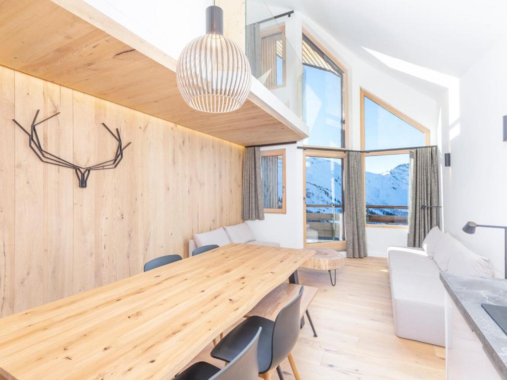 ein Esszimmer mit einem Holztisch und Stühlen in der Unterkunft Luxueux triplex 5 pièces avec mezzanine, rénové, balcon et accès direct aux pistes - FR-1-314-241 in Morzine