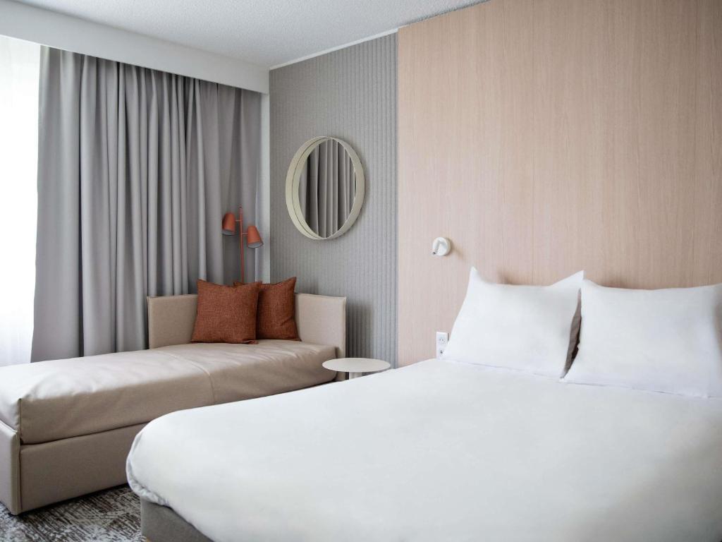 a hotel room with a bed and a couch at Novotel Antwerpen - Ekeren in Antwerp