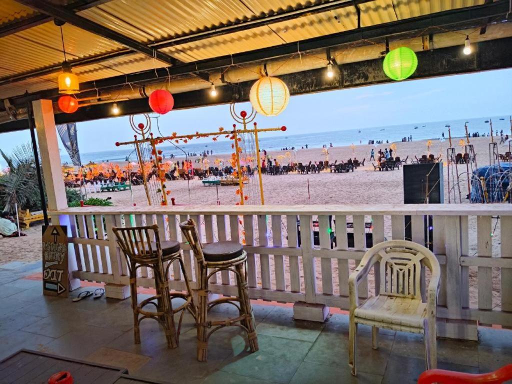 Un patio con sillas y una mesa y una playa. en Roseal Beach Front, en Baga