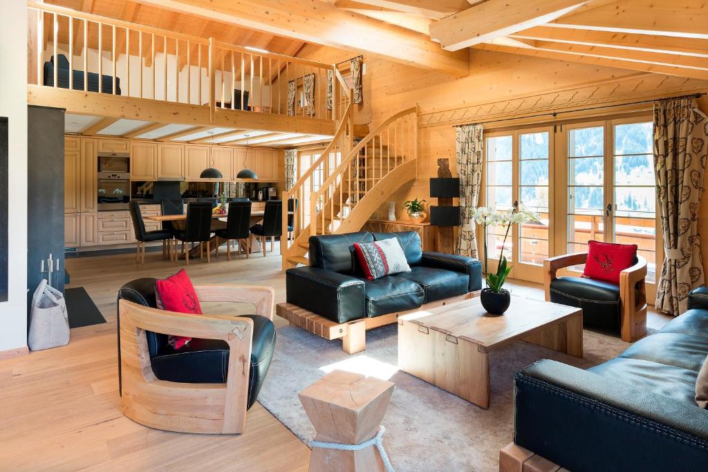 - un salon avec des canapés et une salle à manger dans l'établissement Apartment Alpenblume - GRIWA RENT AG, à Grindelwald