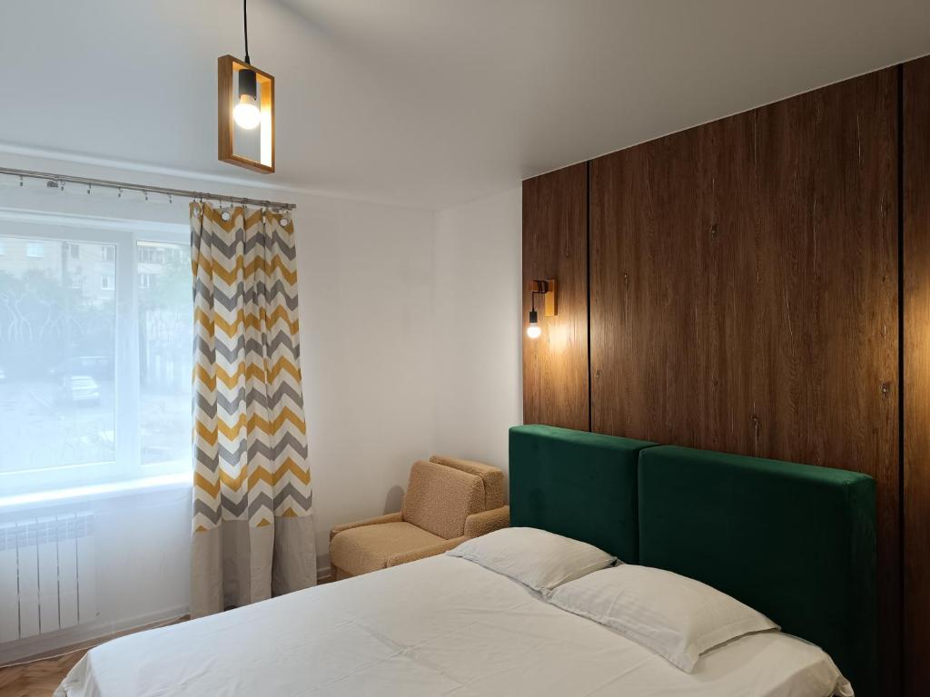 une chambre avec un lit, une chaise et une fenêtre dans l'établissement Zefir Horynia, à Lviv