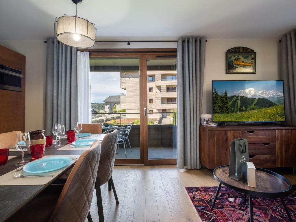 a living room with a dining table and a television at Confortable Appartement Familial aux Saisies avec Balcon et Parking - FR-1-809-6 in Les Saisies